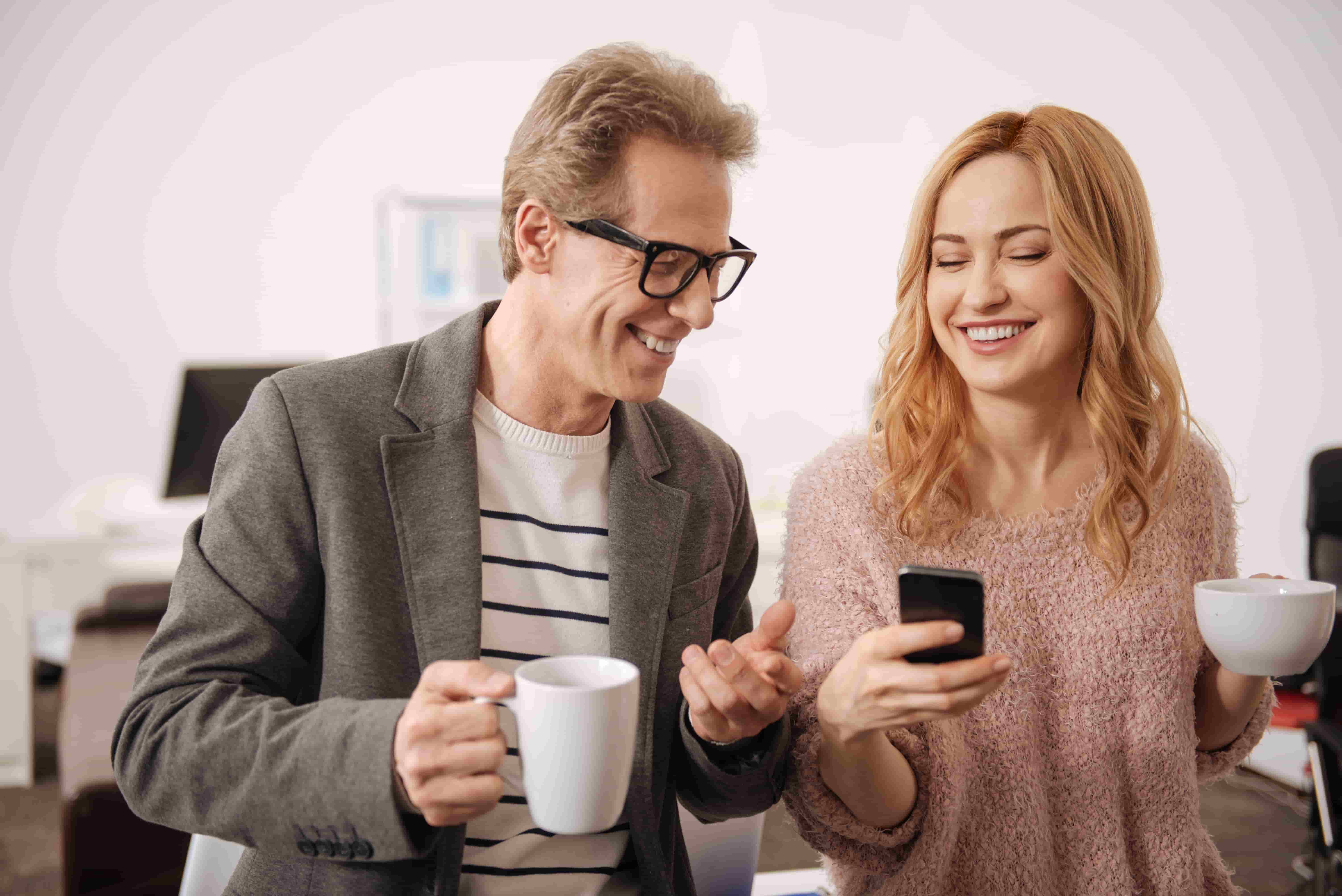 smiling-happy-amused-colleagues-standing-business-center-expressing-positivity-while-enjoying-conversation-drinking-tea_1.jpg